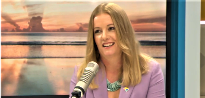 Clinical lead Anna Elders is seated at a desk in the middle of the set at The AM Show. On either side of her, presenters Duncan Garner and Amanda Gillies sit at the same desk.